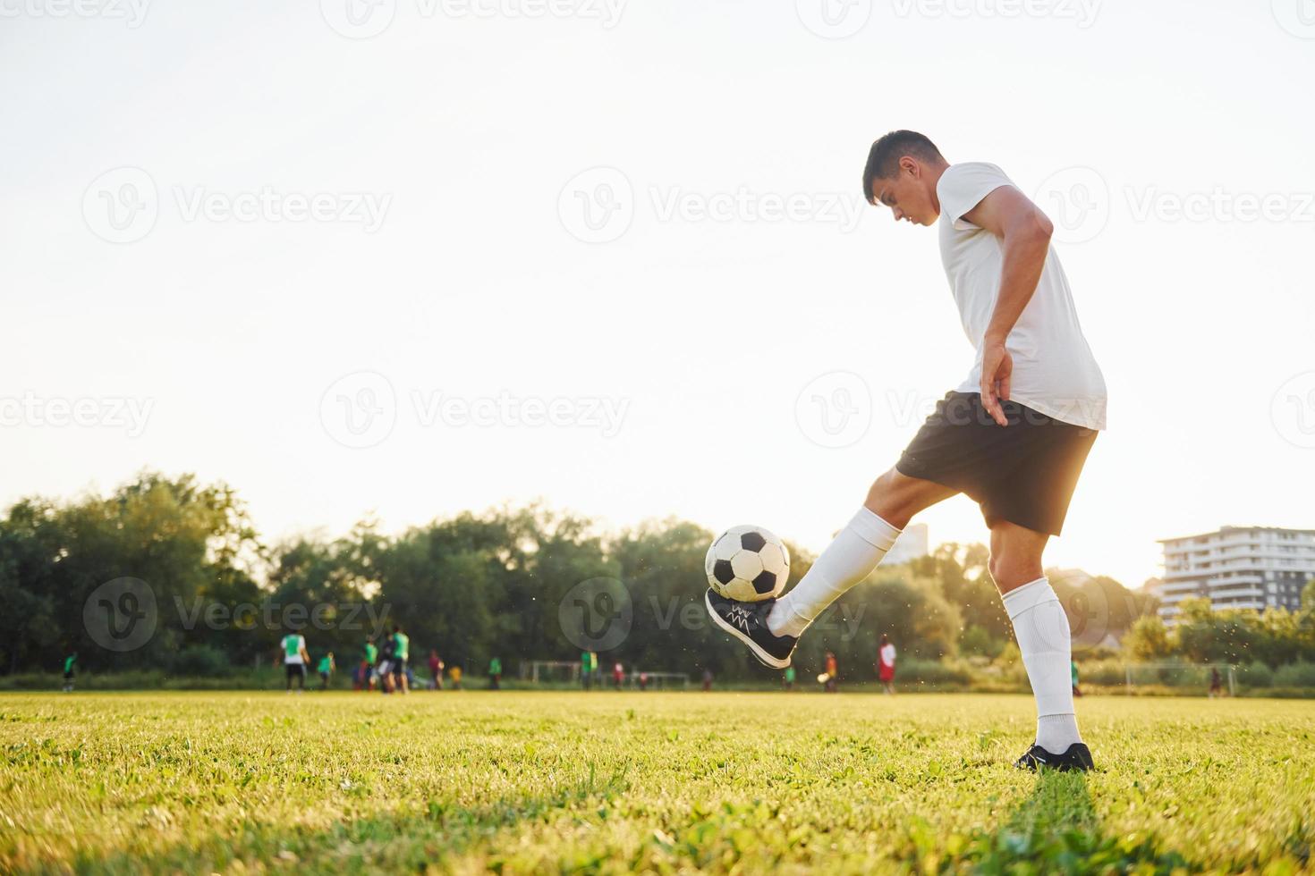 fazendo truques diferentes. jovem jogador de futebol tem treinamento no campo esportivo foto