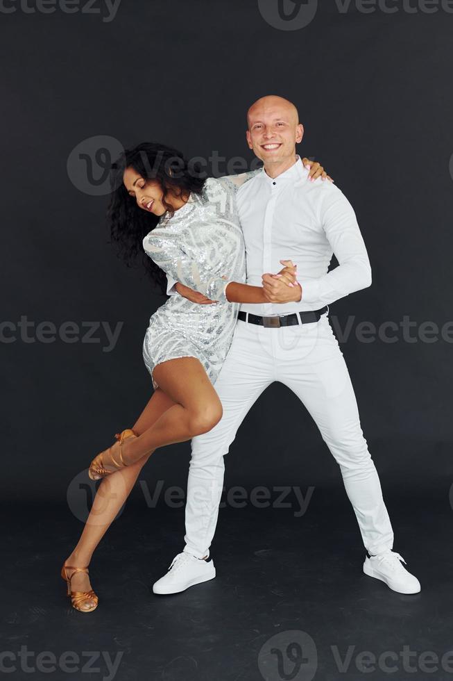 dançando no estúdio. casal alegre está junto dentro de casa foto