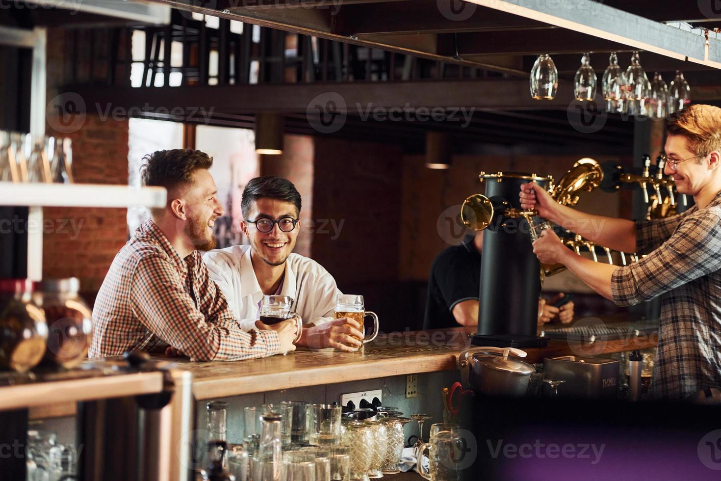 grupo de pessoas em roupas casuais sentadas no bar foto