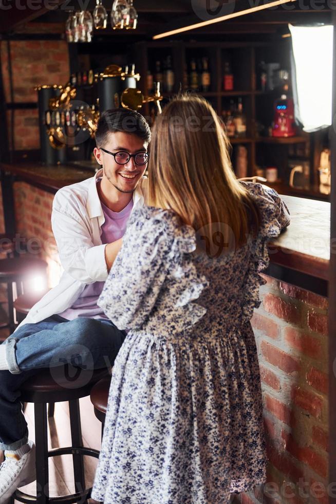 jovens alegres em roupas casuais sentados no pub foto