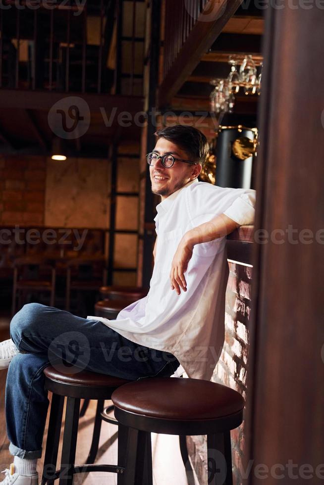 uma pessoa. homem em roupas casuais, sentado no bar foto