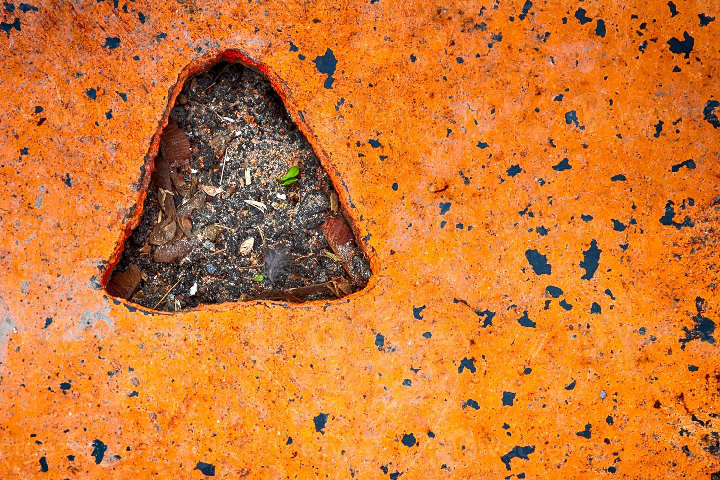 placa de aço laranja em concreto com um orifício triangular foto