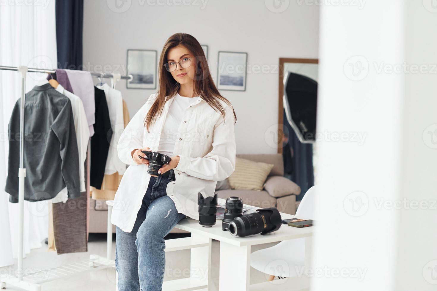 fotógrafo feminino em roupas casuais está trabalhando dentro de casa durante o dia foto