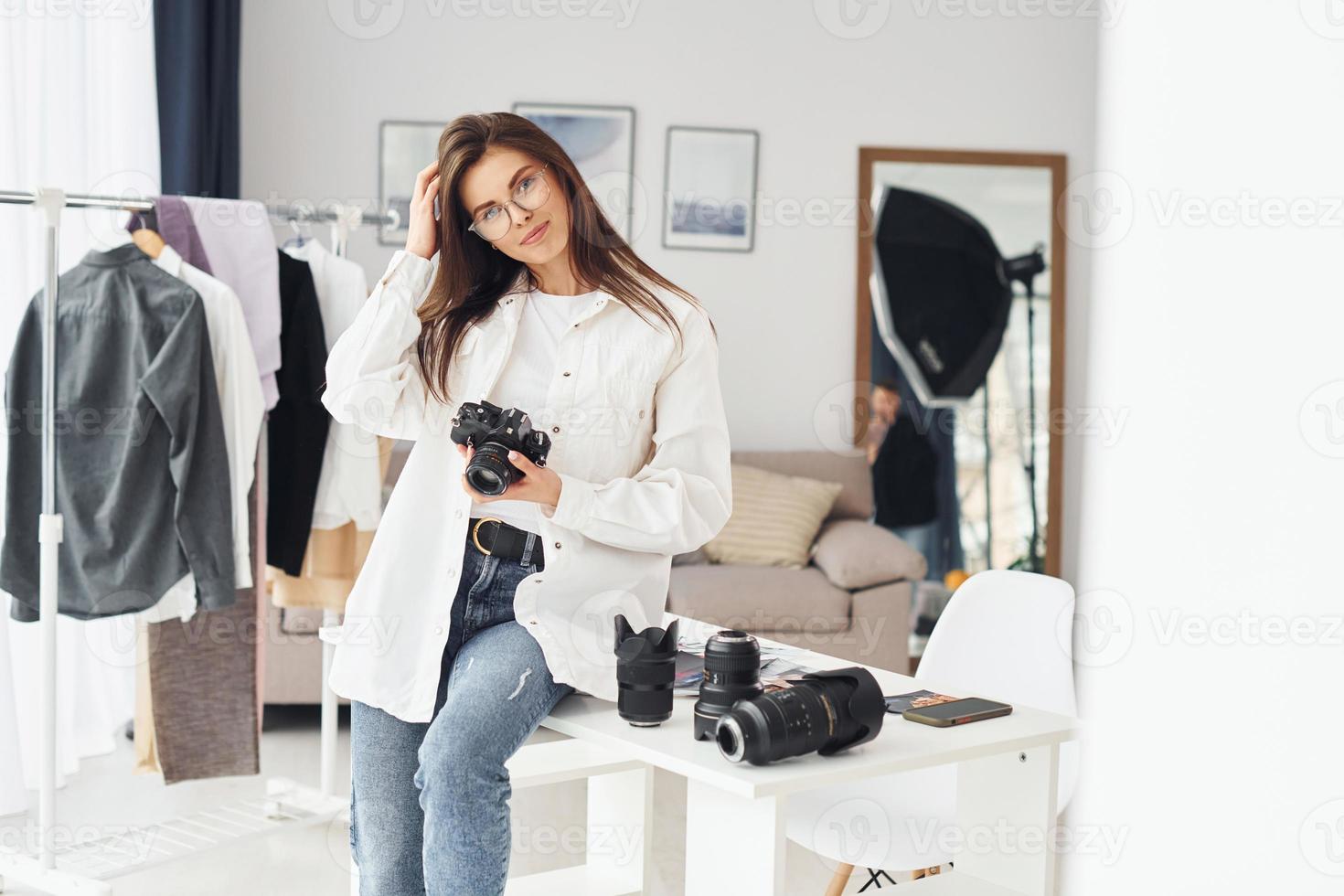 fotógrafo feminino em roupas casuais está trabalhando dentro de casa durante o dia foto