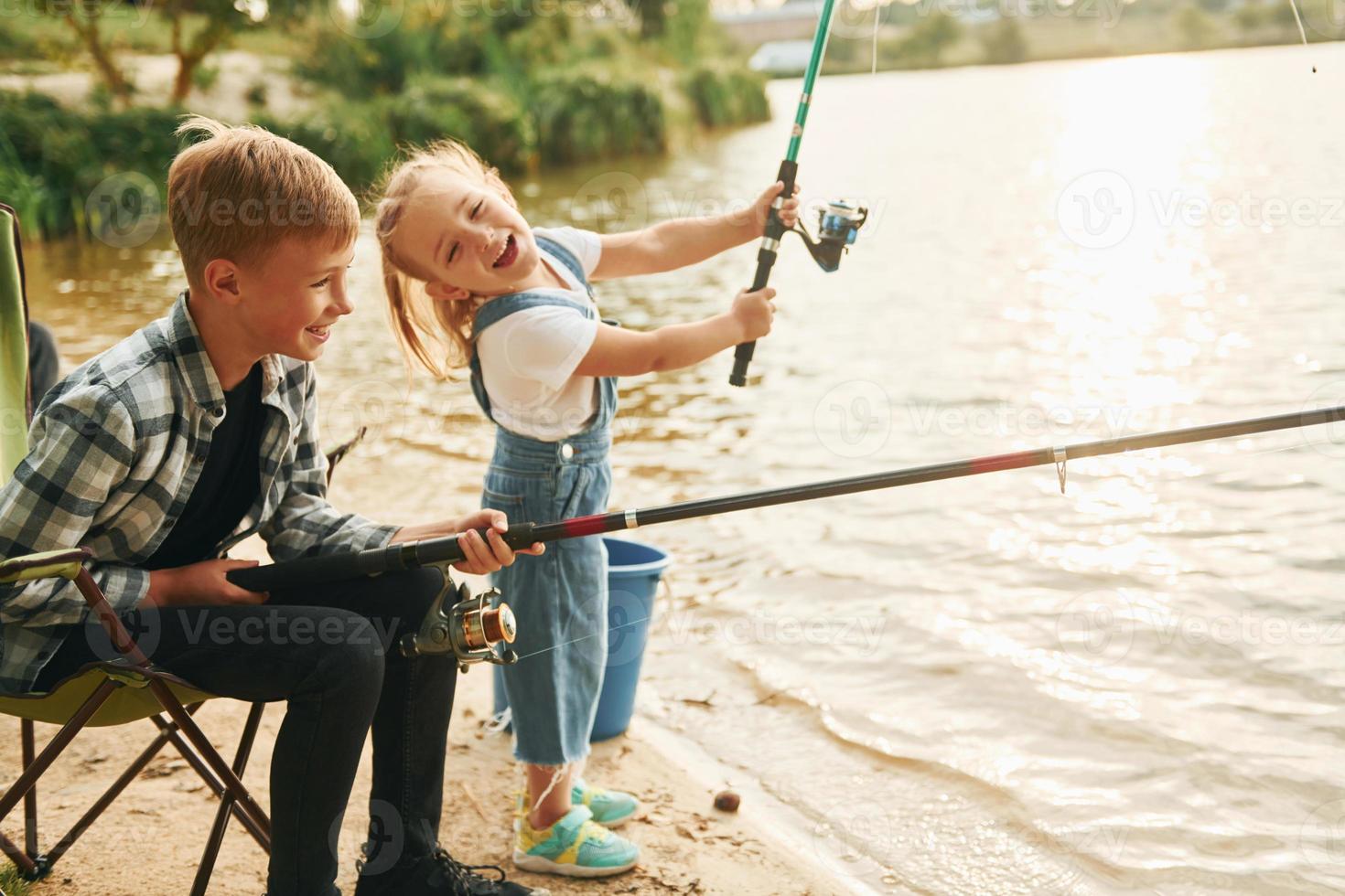se divertindo. menino com sua irmã na pesca ao ar livre no verão juntos foto