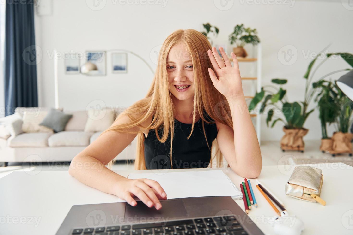 Educação online. adolescente do sexo feminino com cabelo loiro está em casa durante o dia foto