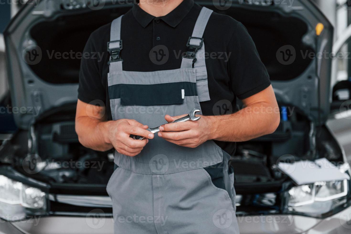 vista de perto. homem de uniforme está trabalhando no autosalon durante o dia foto