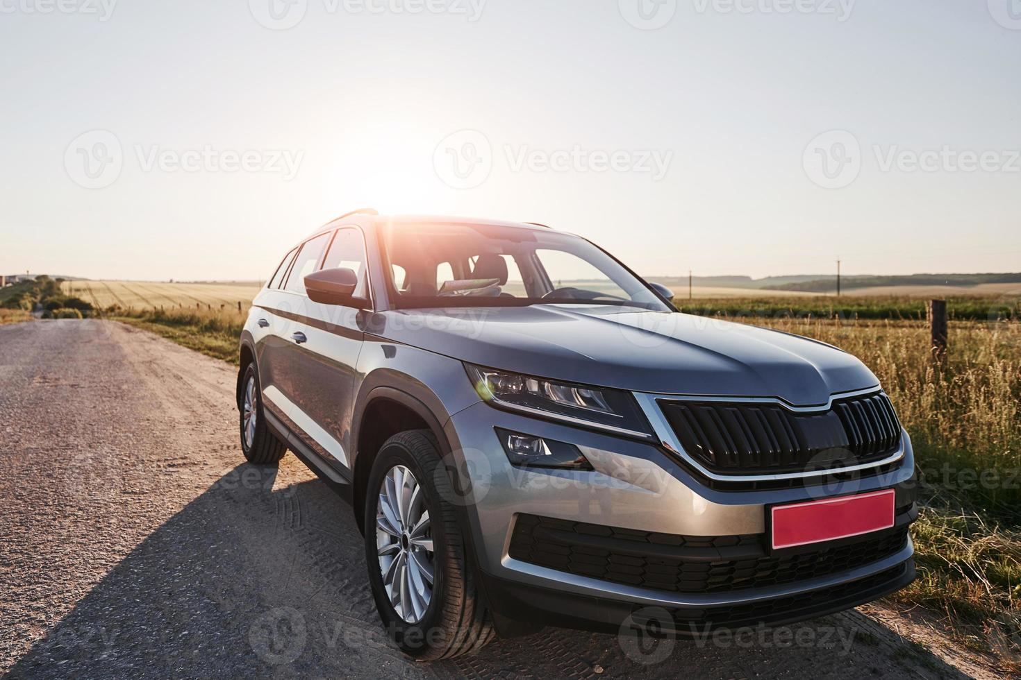 automóvel de luxo. carro novo moderno estacionado na estrada lateral na zona rural durante o dia foto