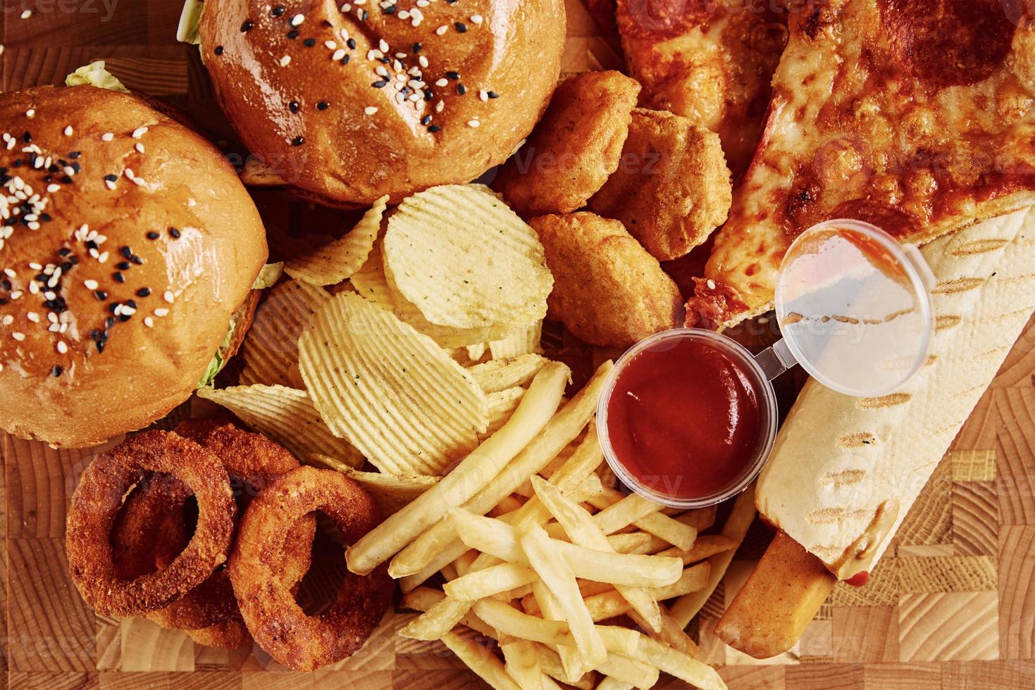 comida insalubre e lixo. diferentes tipos de fast food na mesa, closeup foto