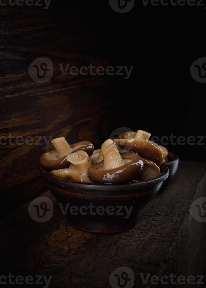 deliciosos cogumelos em conserva em uma bela xícara de barro. foto