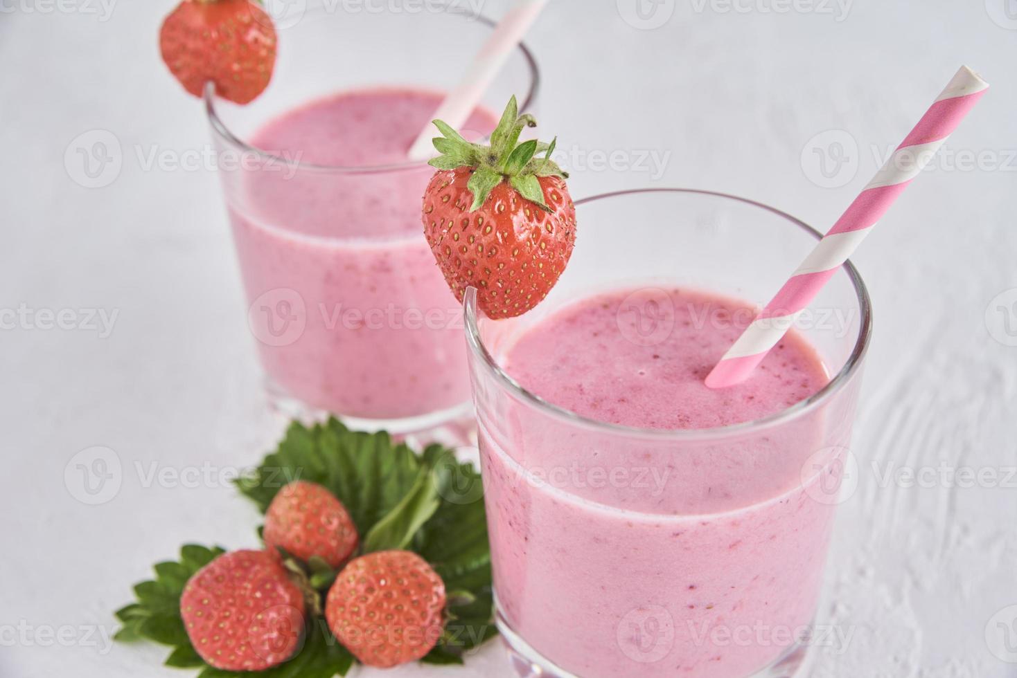 milk-shake de morango em copo com palha e frutas frescas foto