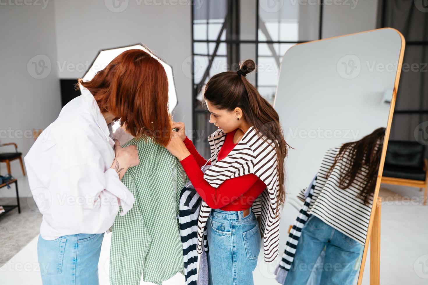 mulher jovem e bonita feliz escolhendo roupas com a namorada. foto