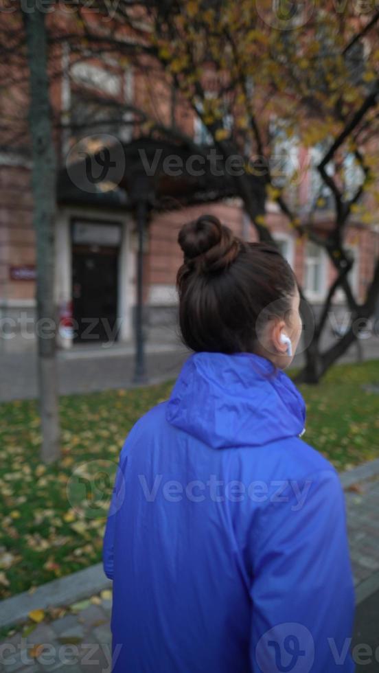 vista traseira de uma mulher adulta correndo ao ar livre em uma rua foto