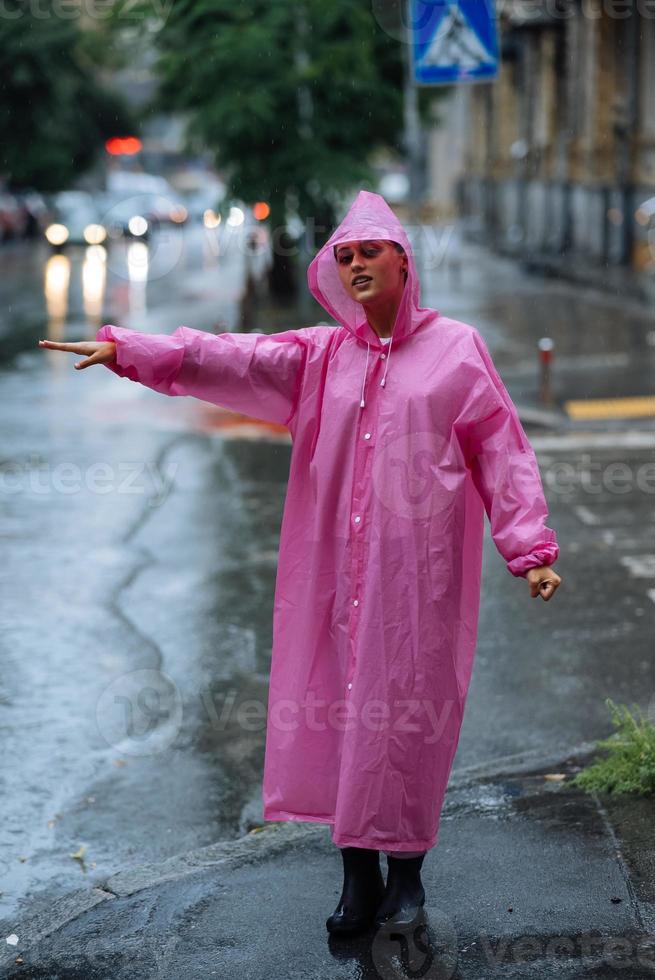 jovem tentando parar um táxi. mulher chamando um táxi em um dia chuvoso. foto