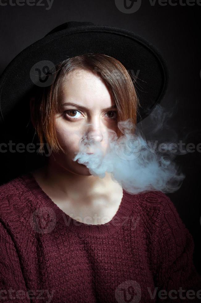 retrato de uma jovem na fumaça dos cigarros foto