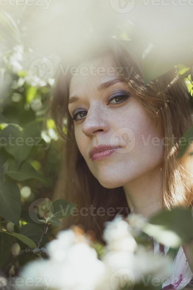 mulher de close-up com maquiagem brilhante, cercada por foto de retrato de flores brancas