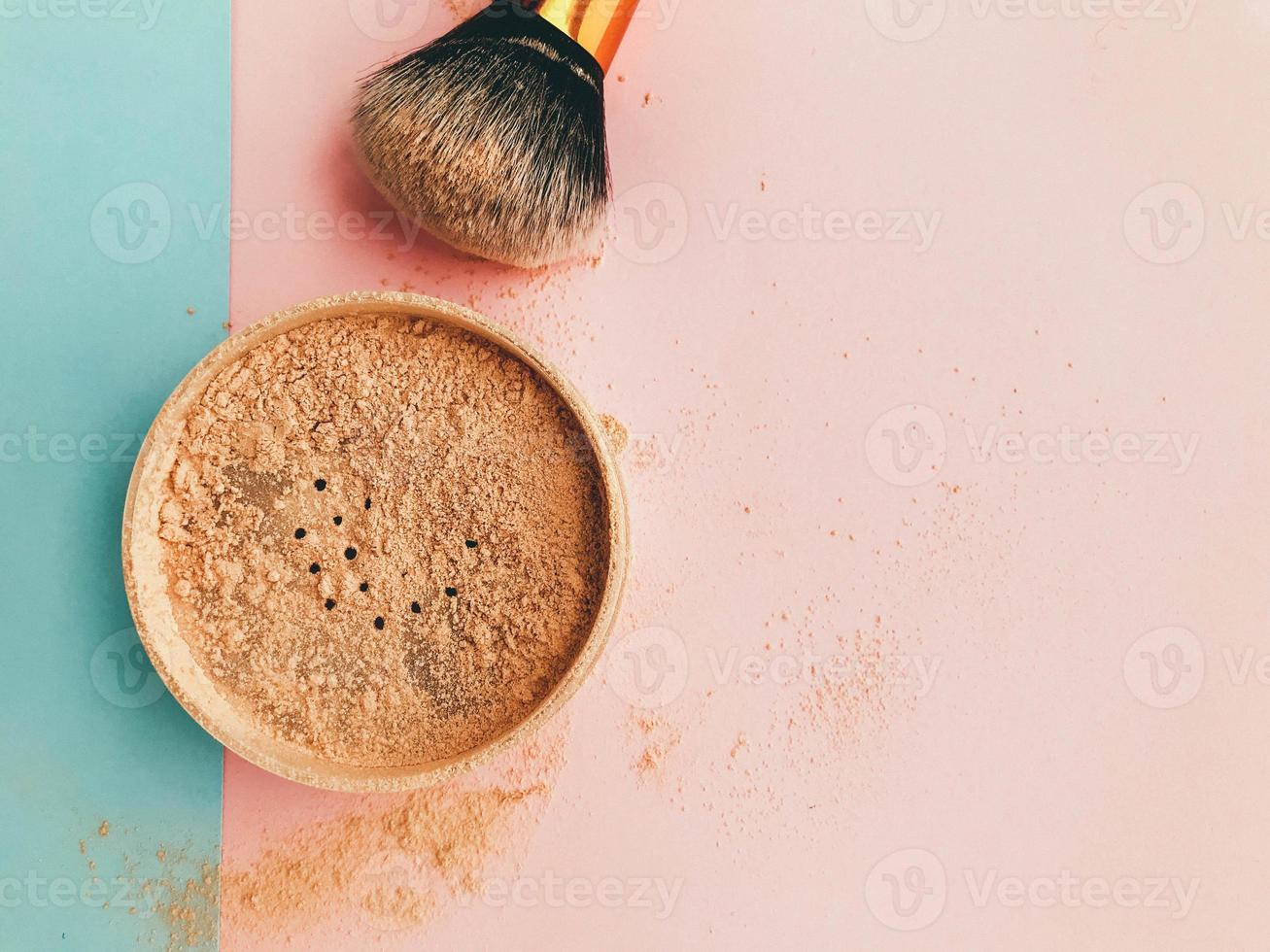 pó fosco solto em um glamoroso fundo rosa e azul. uma ferramenta para um maquiador. maquiagem para o rosto, criação de máscaras e maquiagem. pó mineral foto