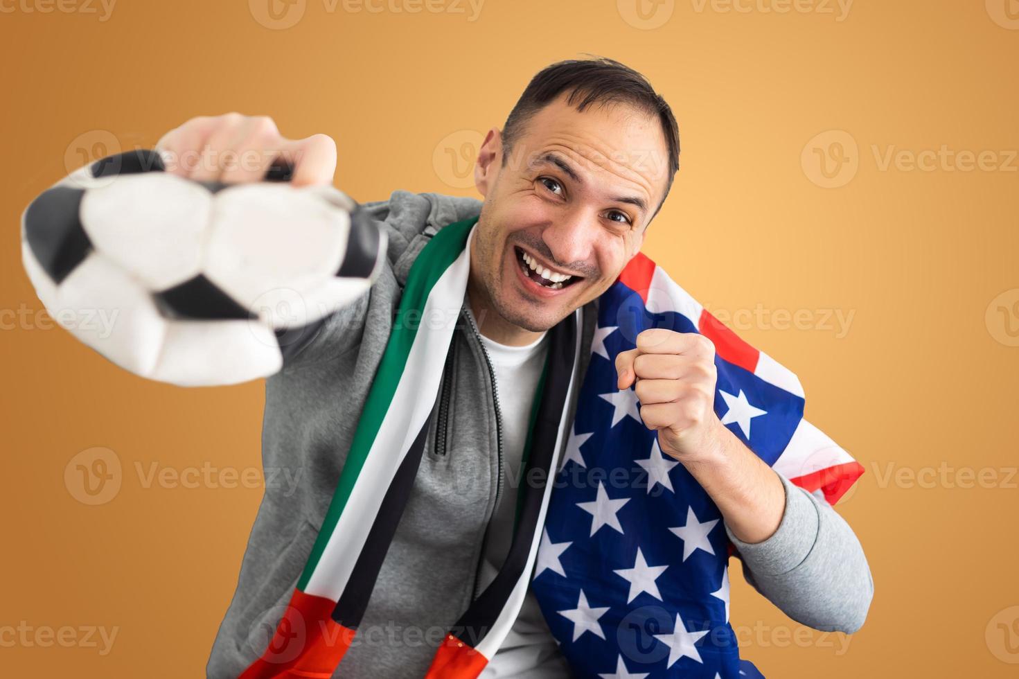 fã de futebol com uma bola amassada deformada e com a bandeira dos Emirados Árabes Unidos e dos EUA foto