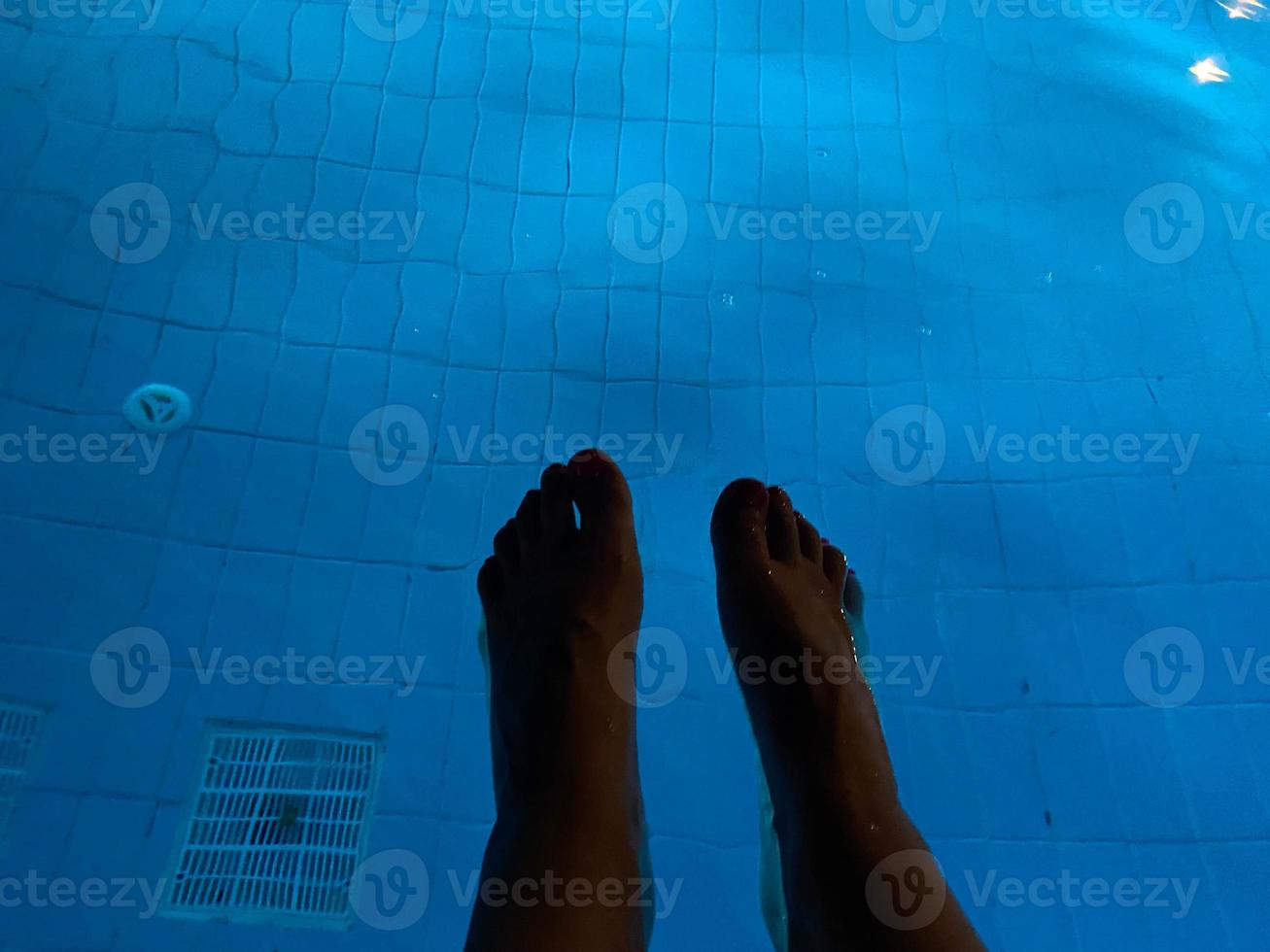 pernas de homem na piscina para relaxar foto