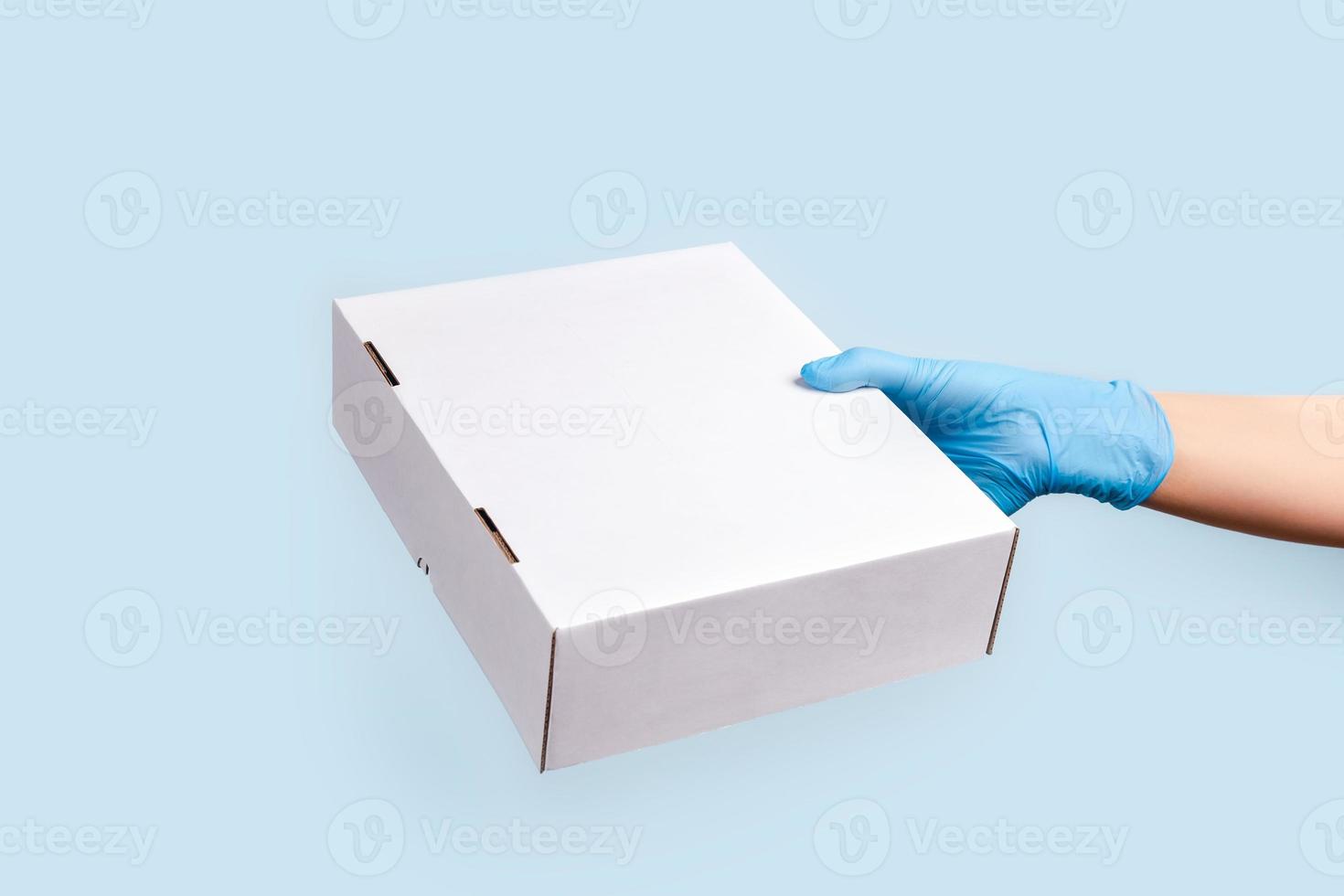 um fundo azul com a mão segurando uma caixa. foto