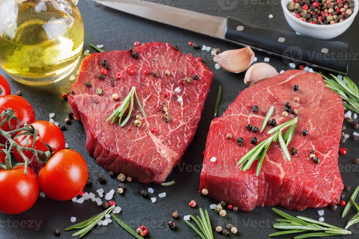 bife de carne crua fresca com especiarias no fundo preto foto