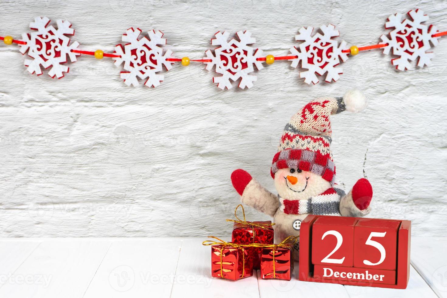 árvore de natal decorativa, caixas de presente e calendário de madeira em fundo branco de madeira. foto