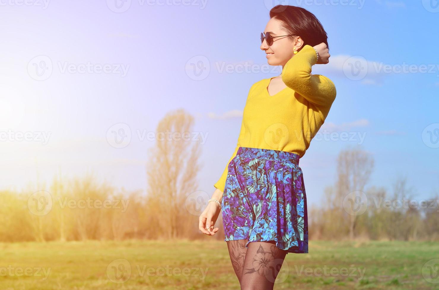 garota morena atraente e bonita em um suéter amarelo caminha thro foto