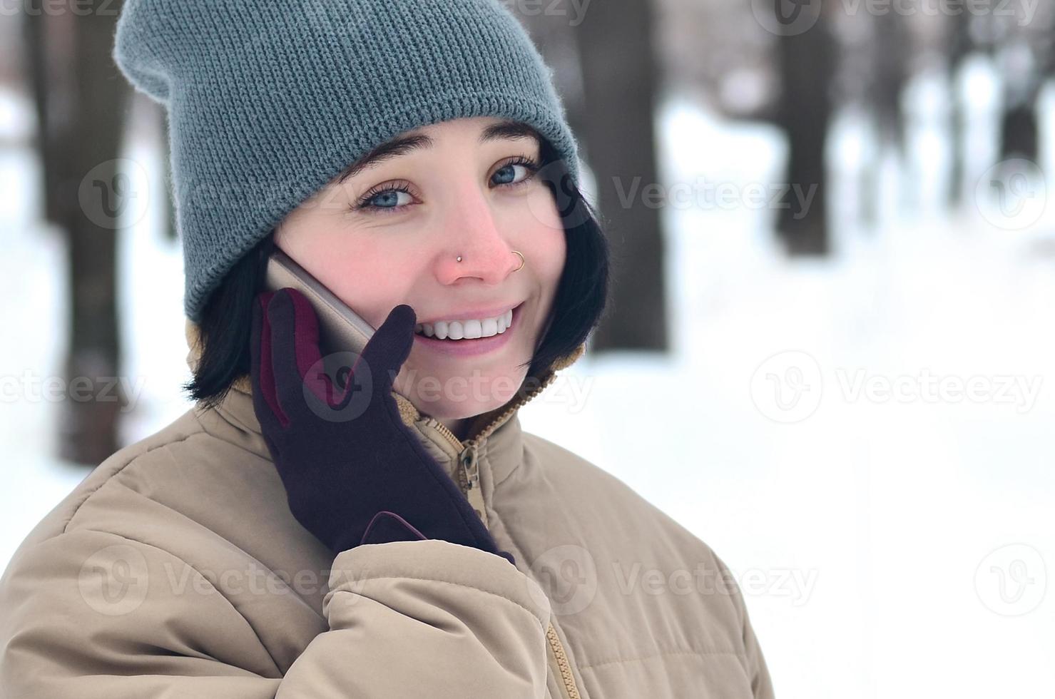 retrato de inverno de jovem com smartphone foto