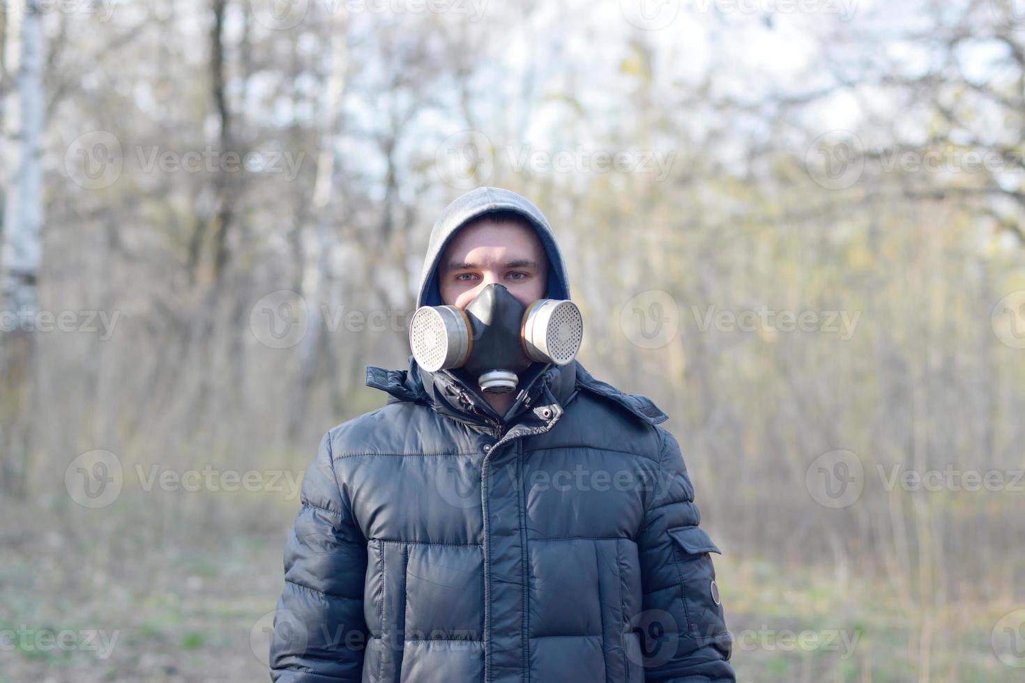 retrato de jovem em máscara de gás protetora ao ar livre em madeira de primavera foto