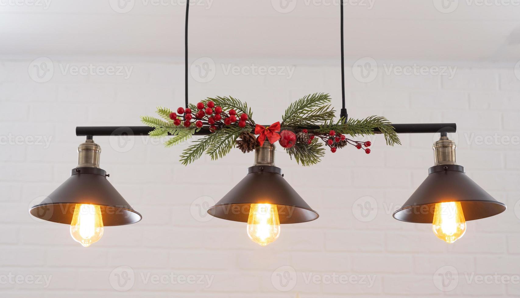 o abajur preto no estilo loft industrial é decorado com ramos de abeto para o natal e ano novo na parede de tijolos brancos de fundo. close-up, minimalismo foto