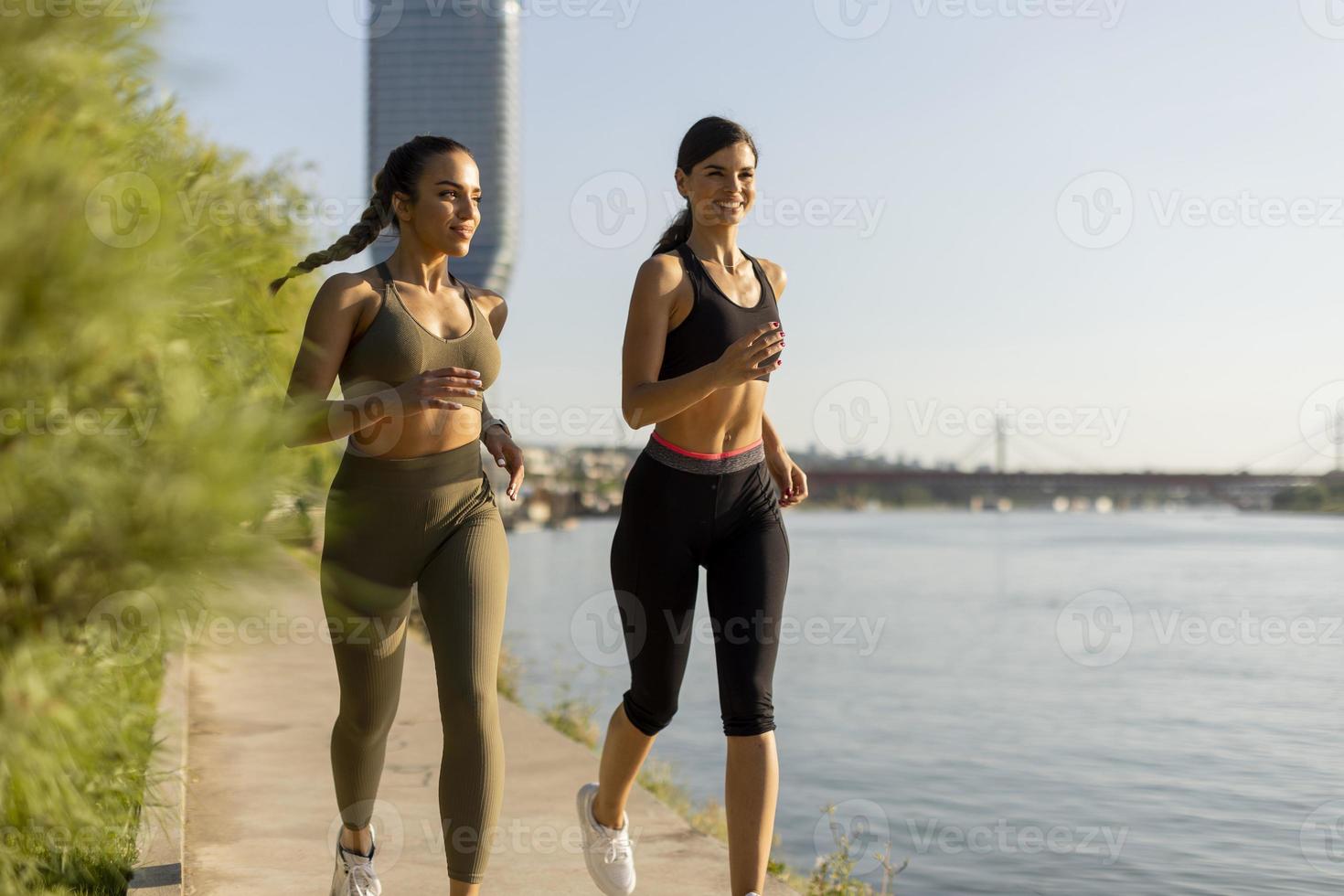 jovem fazendo exercícios de corrida à beira do rio foto