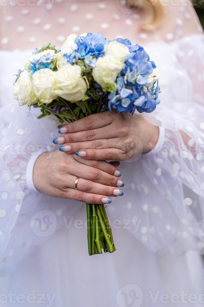 a noiva em um vestido de noiva branco está segurando um buquê de flores  brancas - peônias,