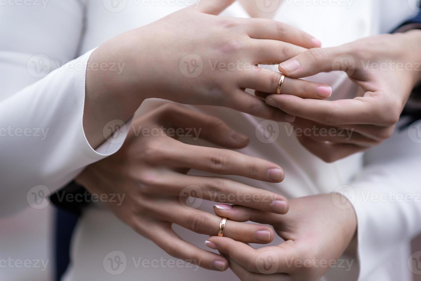 mãos da noiva e do noivo com anéis. noiva e noivo em um café. mesa de buquê de casamento. noiva e noivo seguram as mãos um do outro. alianças de casamento. casal apaixonado em um café. chá quente para os amantes foto