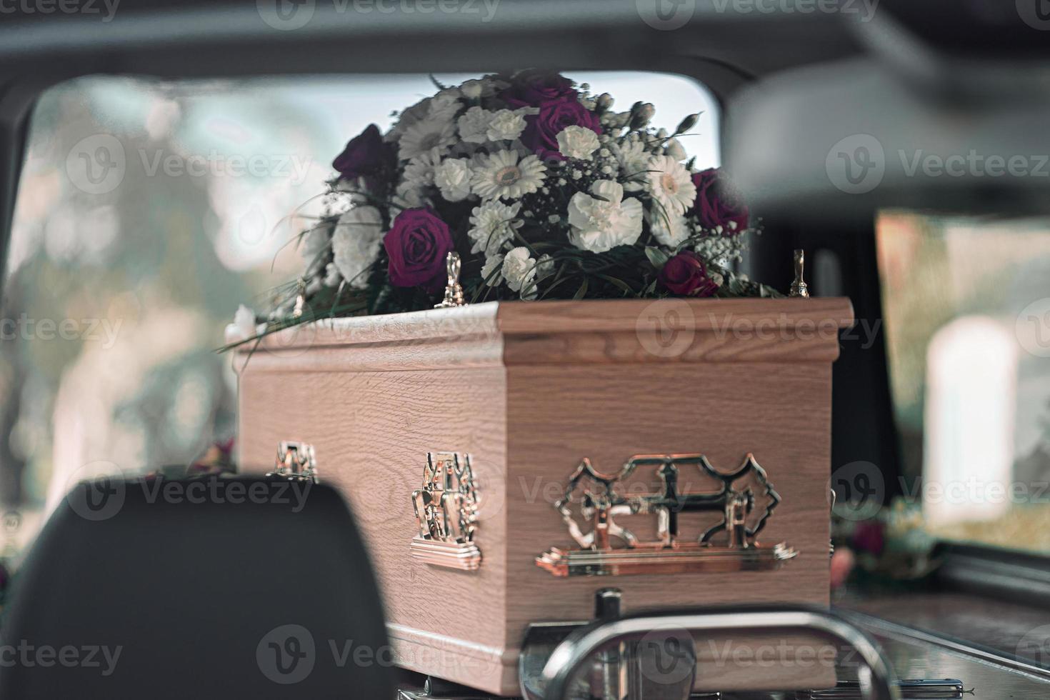flores fúnebres rosas brancas e lírios dentro de um carro funerário em um funeral em um dia lindo e triste foto