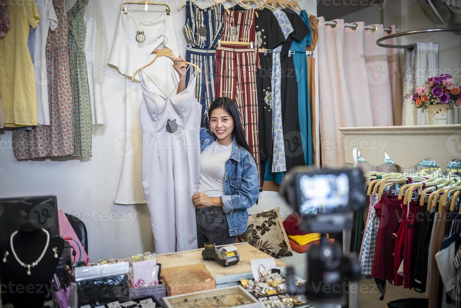 blogueira de moda feminina de beleza apresentando vestido para celular e sorrindo mostrando roupas vendendo transmissão ao vivo online foto