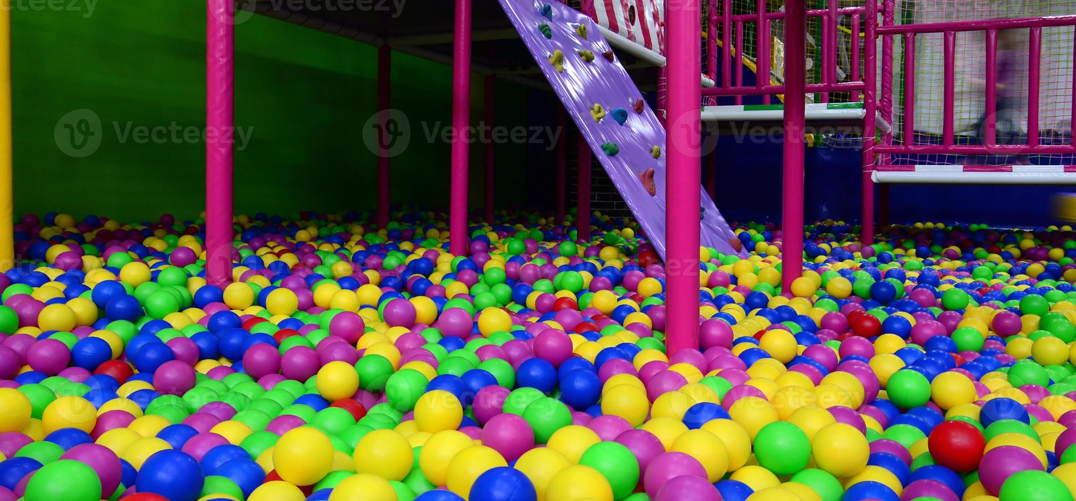 muitas bolas de plástico coloridas em uma piscina infantil em um playground foto