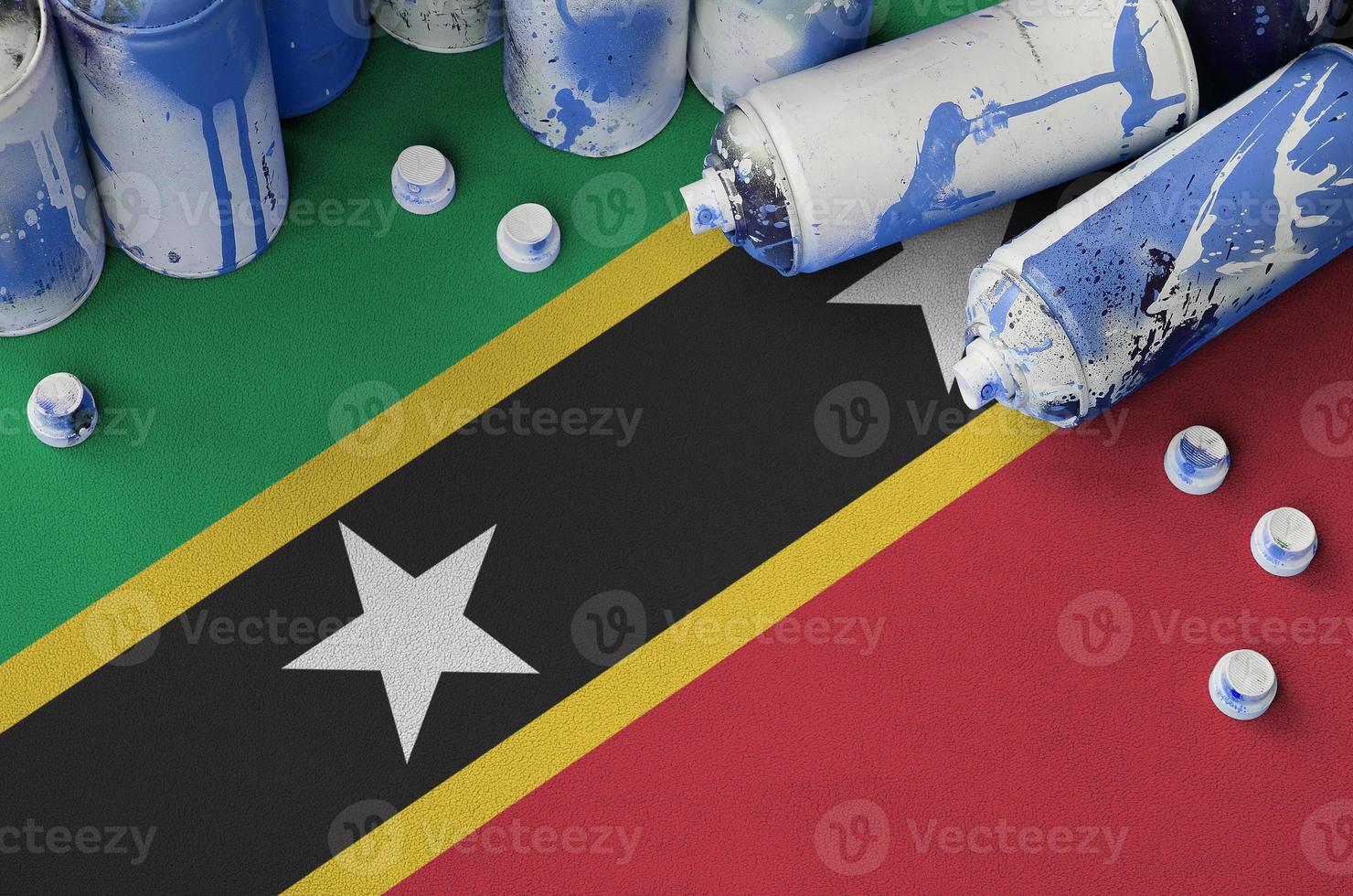 Bandeira de São Cristóvão e Nevis e poucos aerossóis usados para pintura de graffiti. conceito de cultura de arte de rua foto