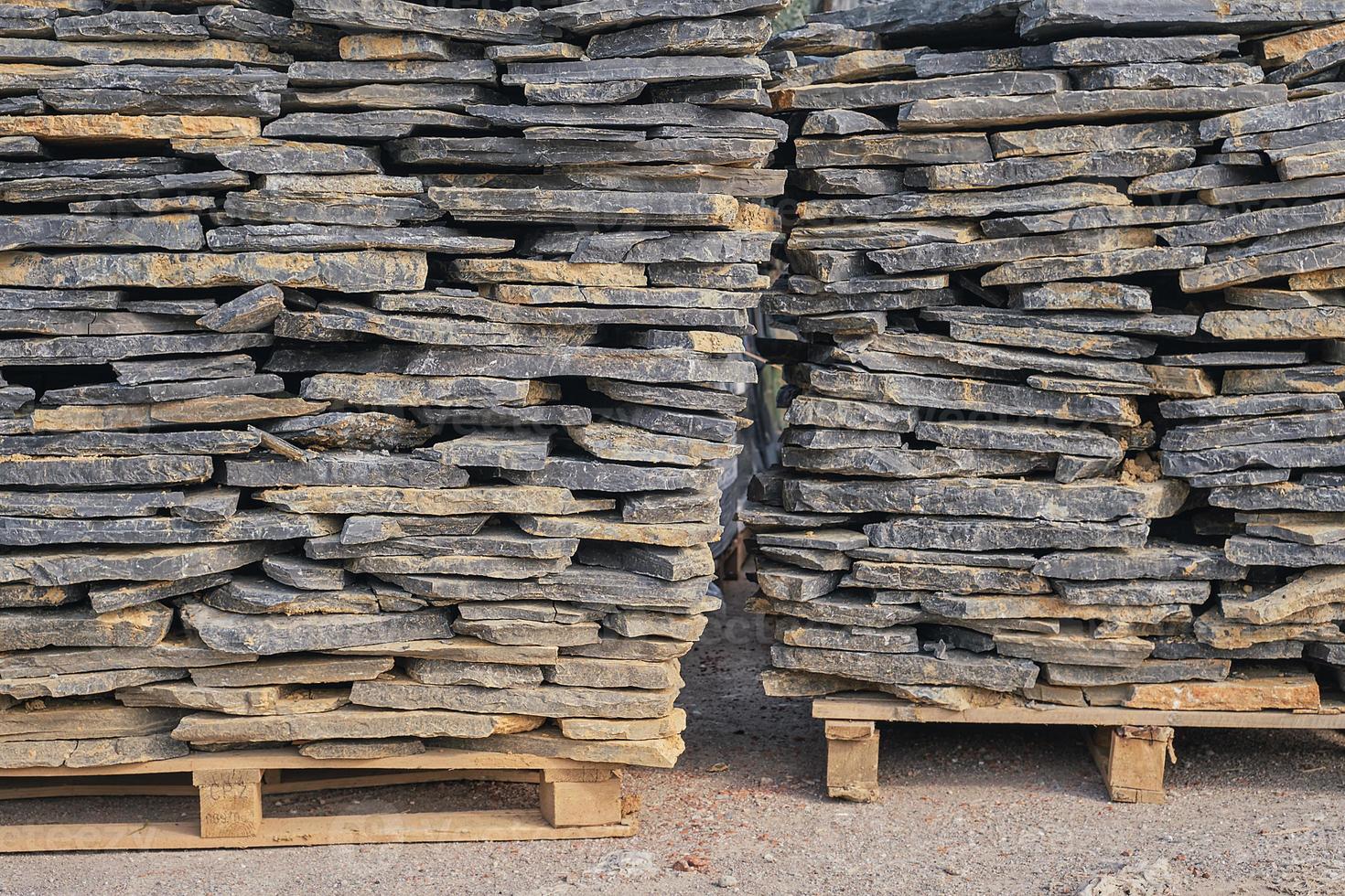 lajes de pedra natural para acabamento e decoração de paredes interiores e exteriores de edifícios em paletes, foco seletivo. mercadorias em estoque, construção e reparo, entrega e venda de materiais de construção. foto