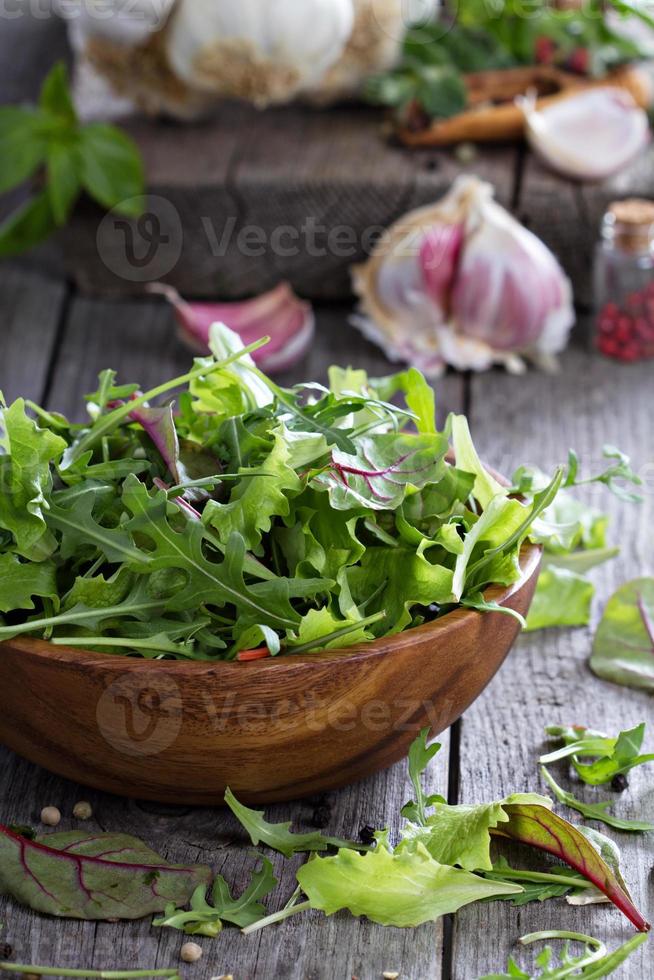 salada verde de folhas em uma tigela de madeira foto