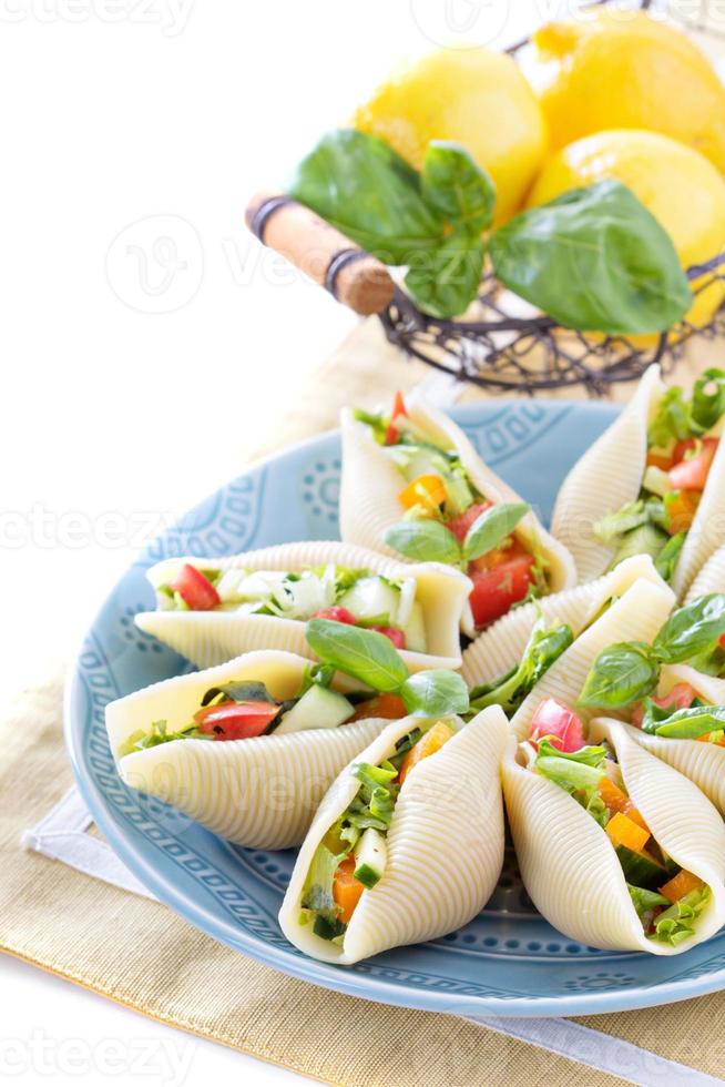 salada de legumes servida em conchas de macarrão foto