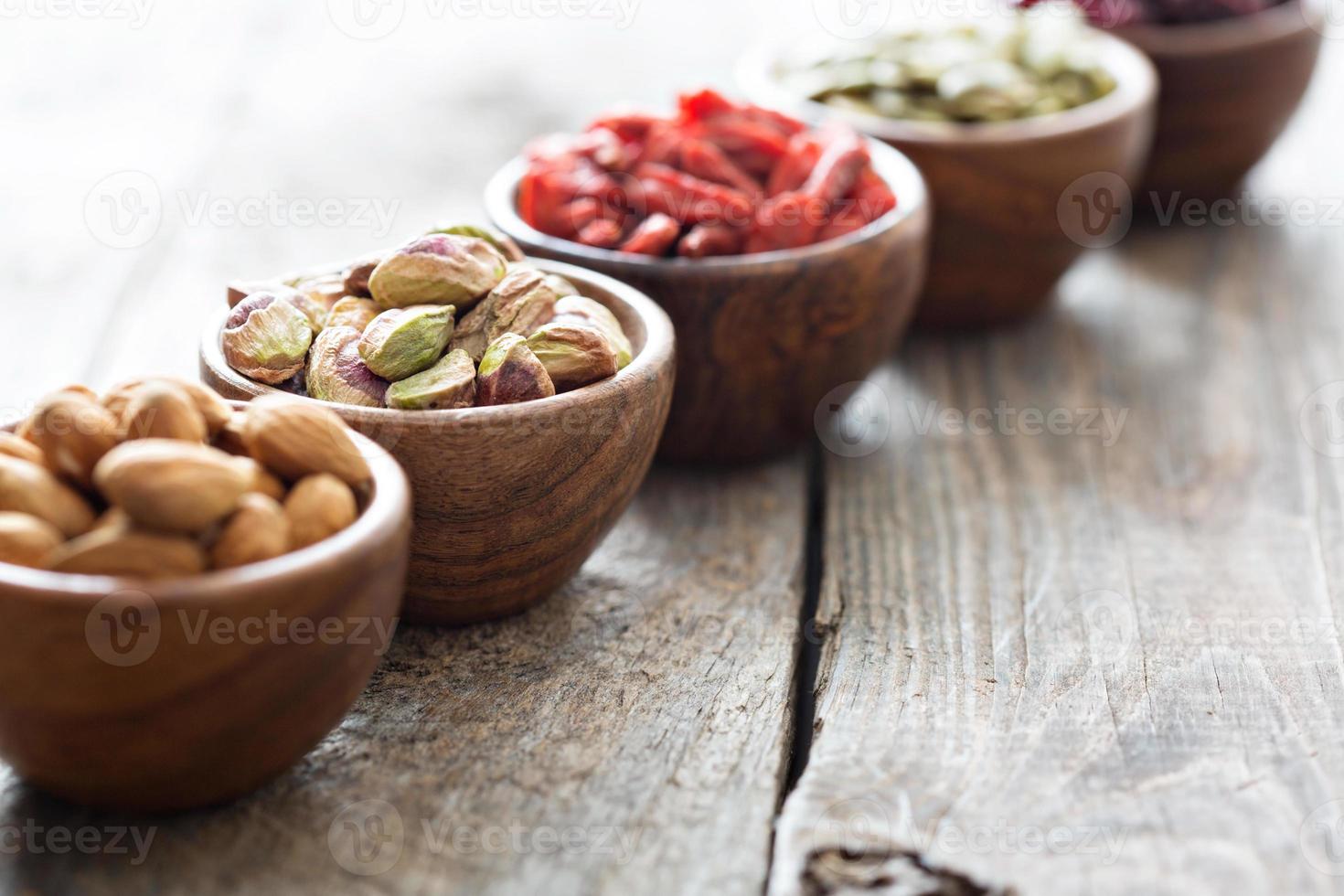 variedade de nozes e frutas secas em pequenas tigelas foto