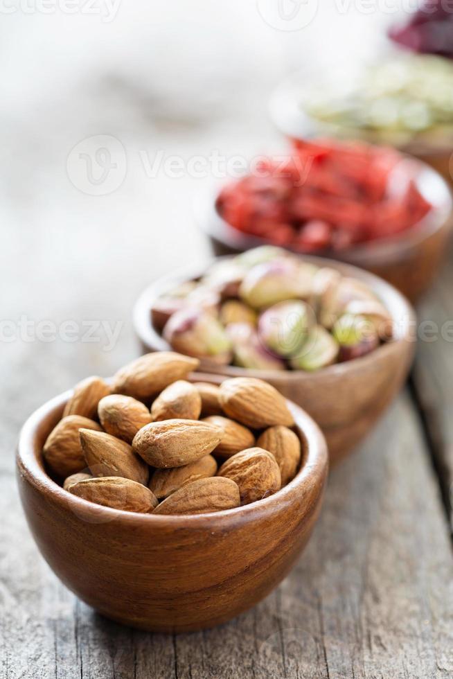 variedade de nozes e frutas secas em pequenas tigelas foto