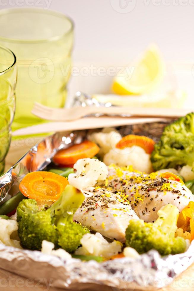 frango com limão e legumes cozidos em papel alumínio foto