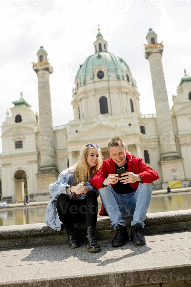 jovem casal usando telefone celular em viena, áustria foto