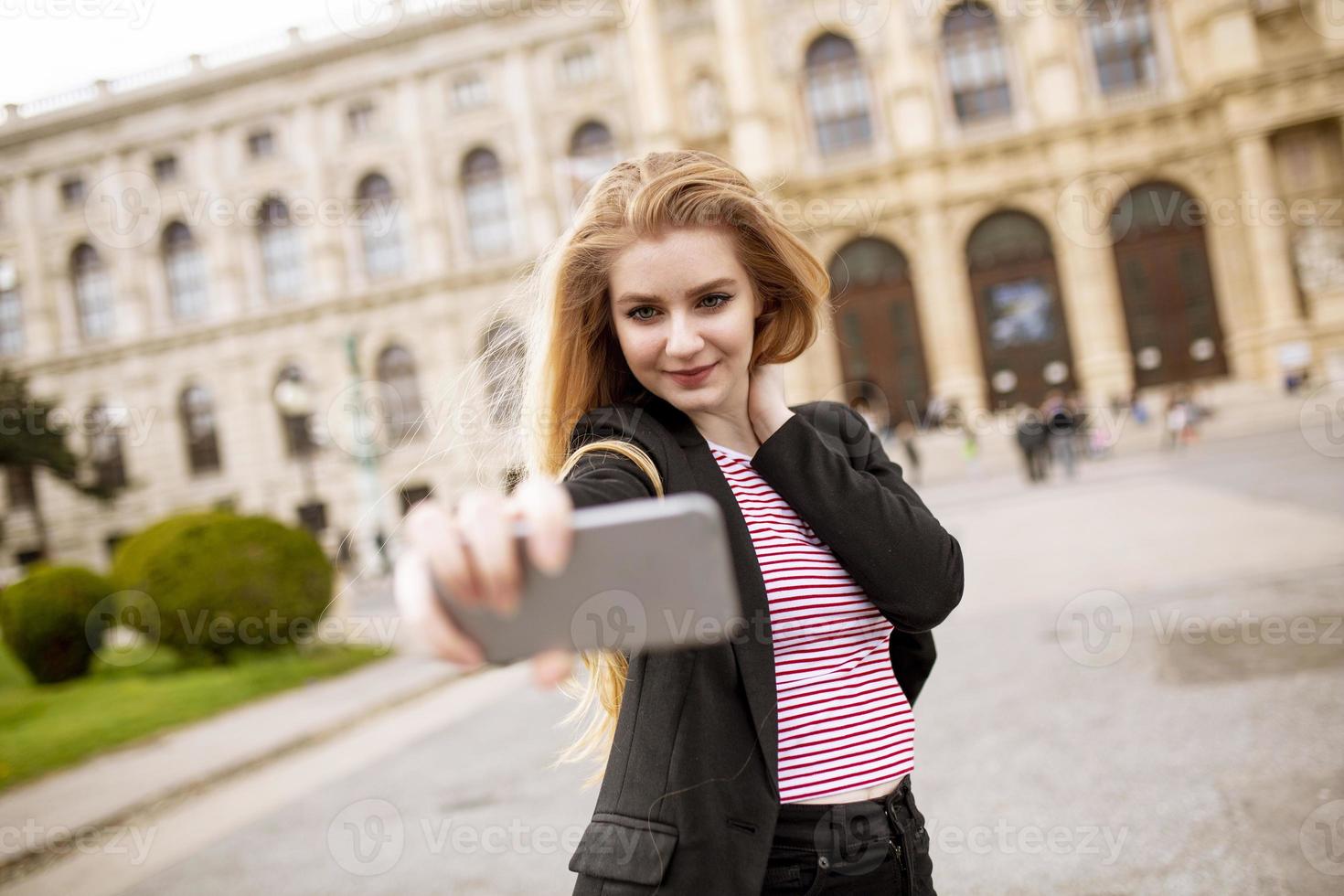 jovem turista feminina tirando selfie com foto móvel no centro de Viena, Áustria