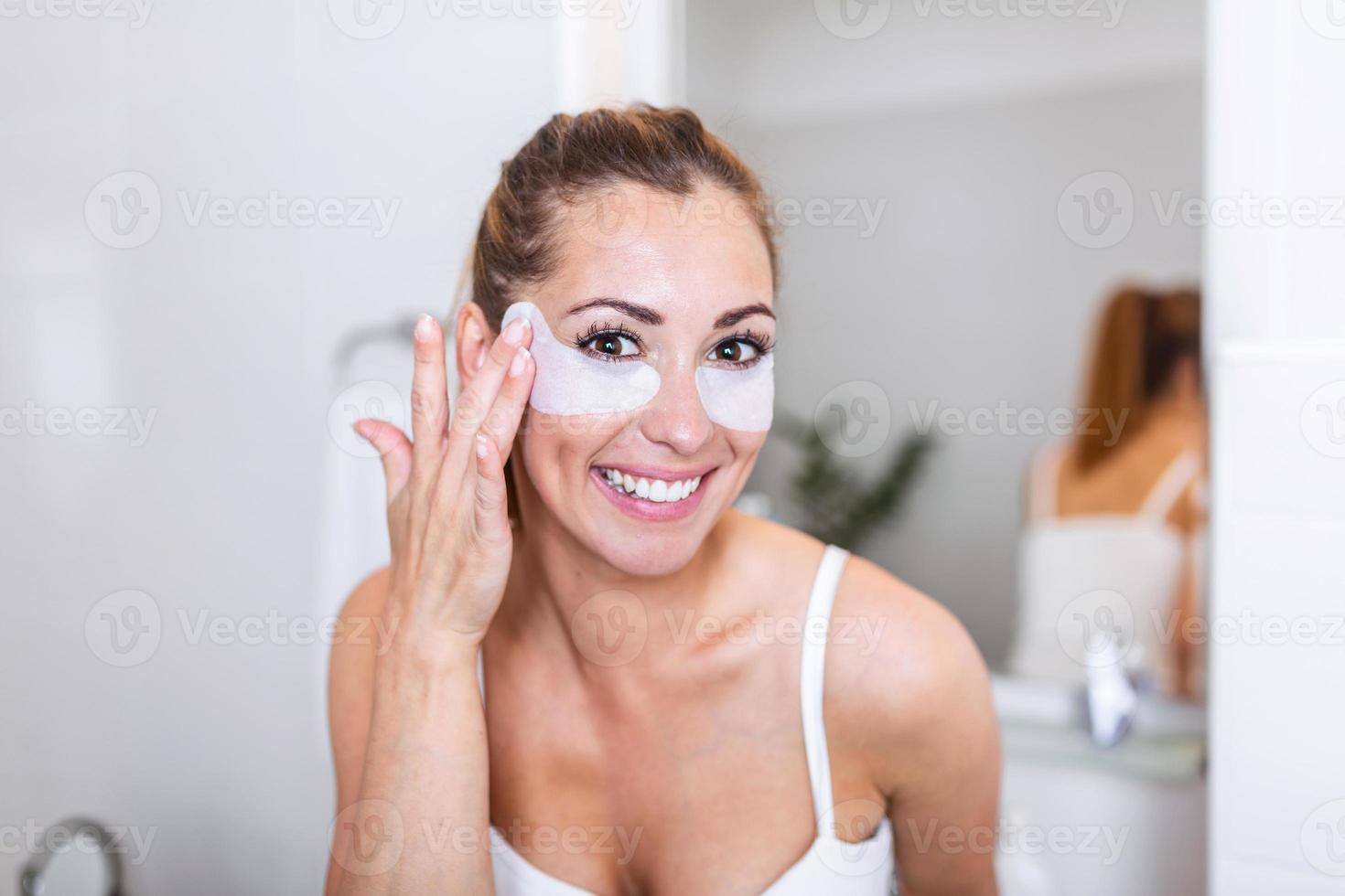 mulher de beleza aplicando máscara sob os olhos olhando-se no