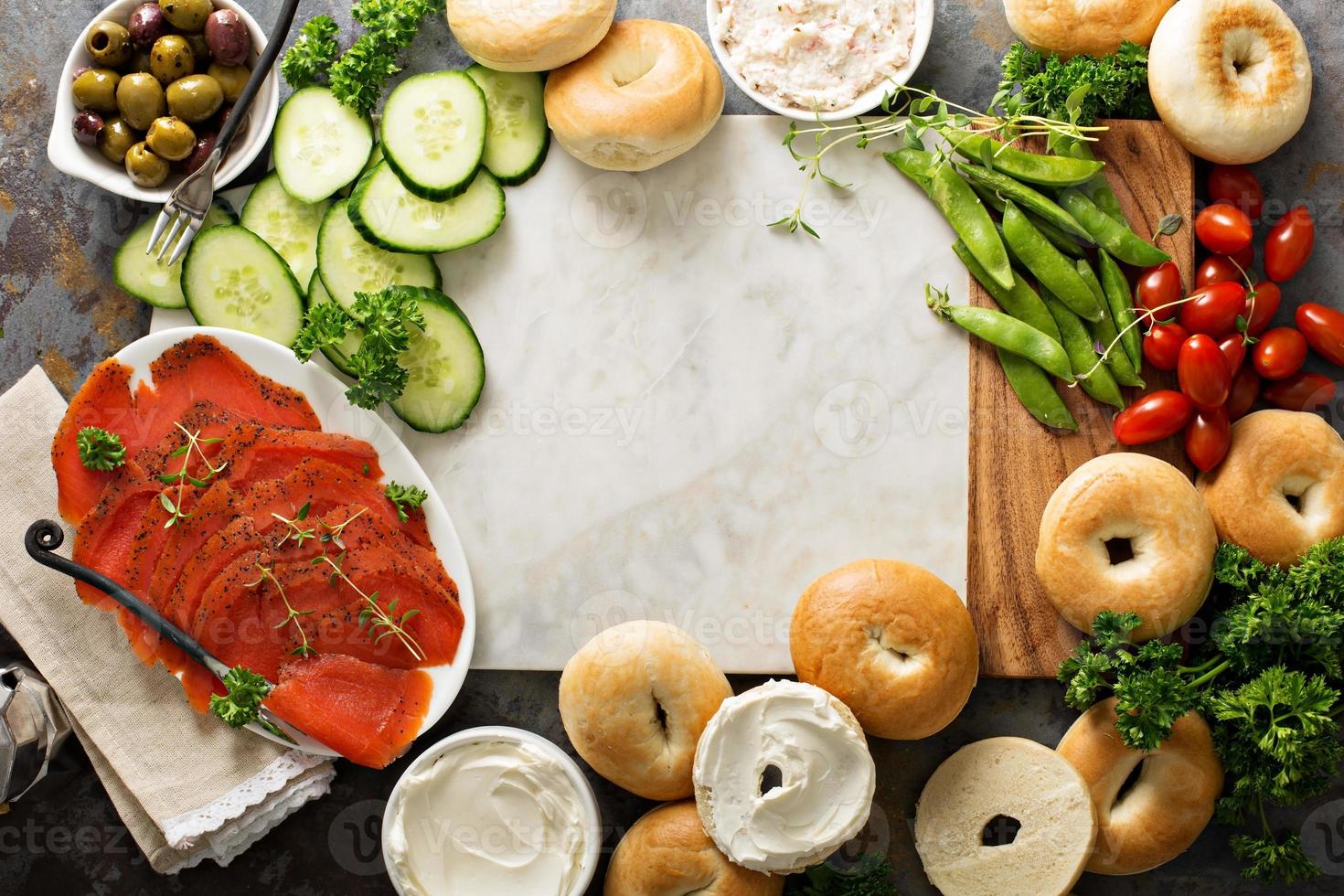 grande prato de café da manhã com bagels, salmão defumado e legumes foto