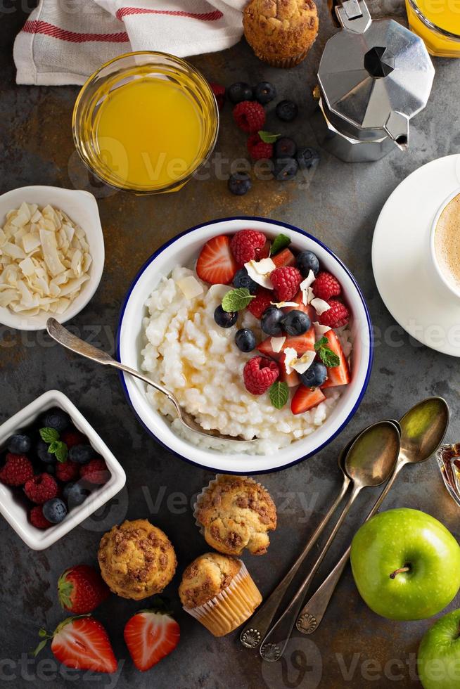 mesa de café da manhã com pudim de arroz, frutas e muffins foto