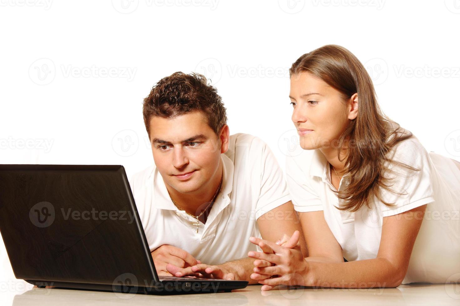 jovem casal usando um laptop foto