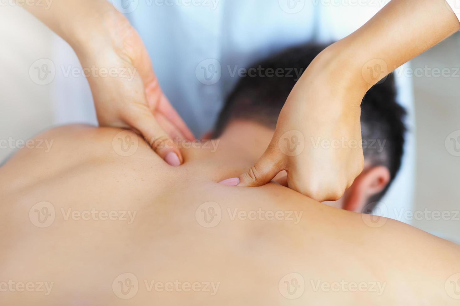 homem bonito tendo massagem no salão spa foto